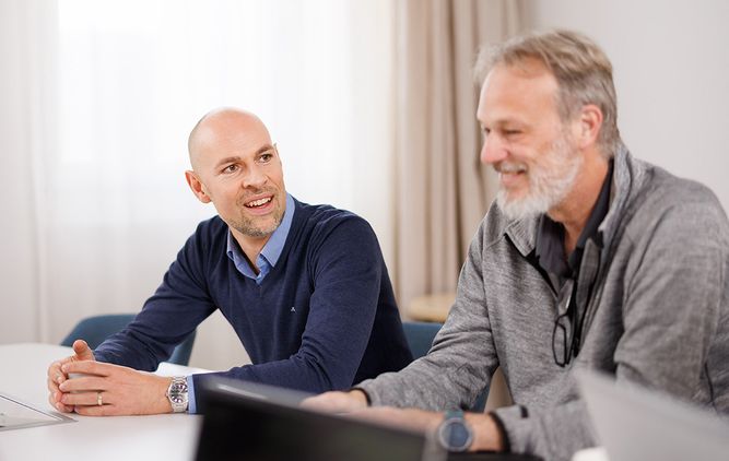 Two Camurus employees are sitting at a table. 